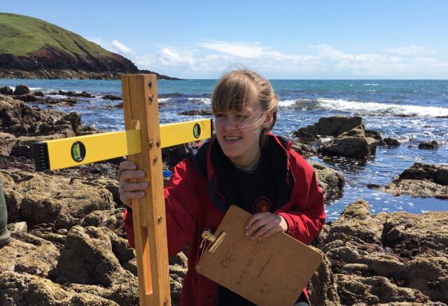Girl on coast measuring whilst on Field Trip