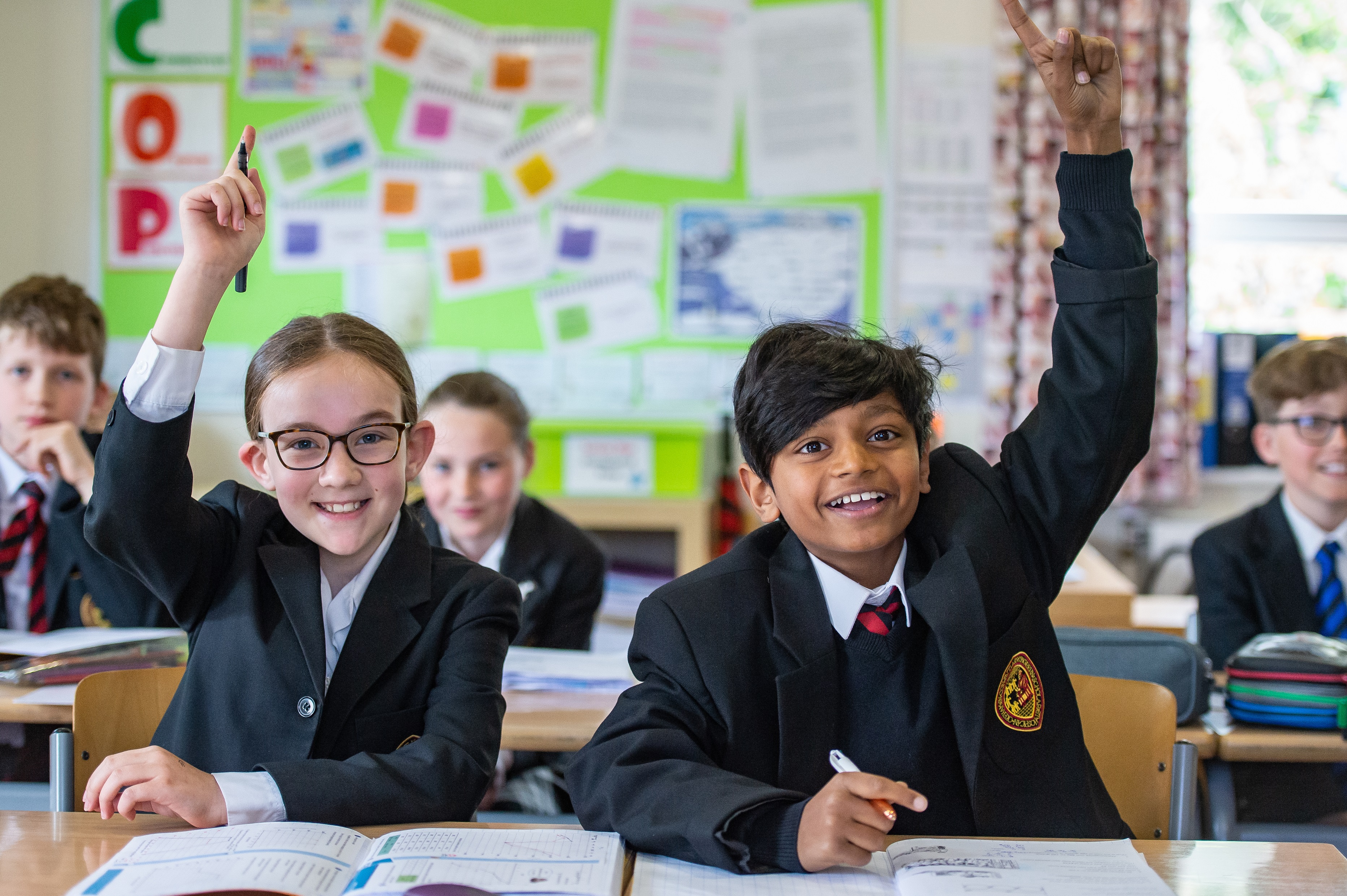 Academic Lower School Classroom pupils raising hands