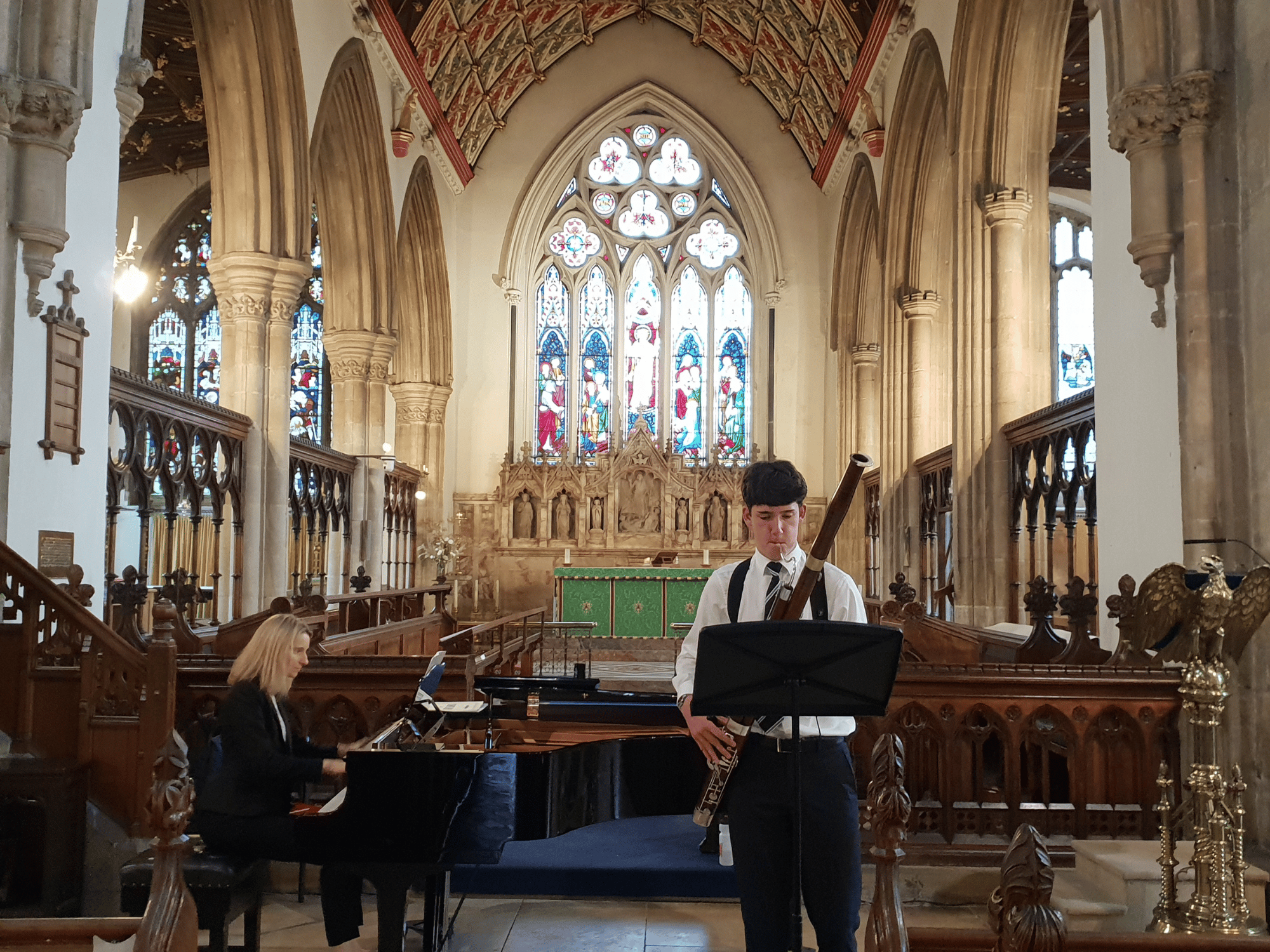 Student plays bassoon in a church accompanied by a pianist