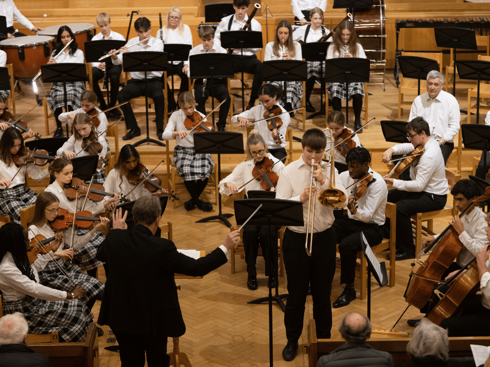 School orchestra play with solo trombone in concert
