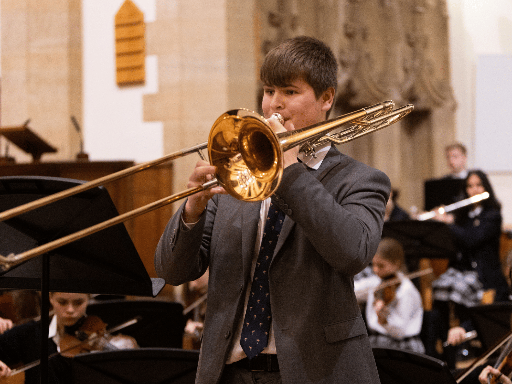Student plays trombone solo with orchestra