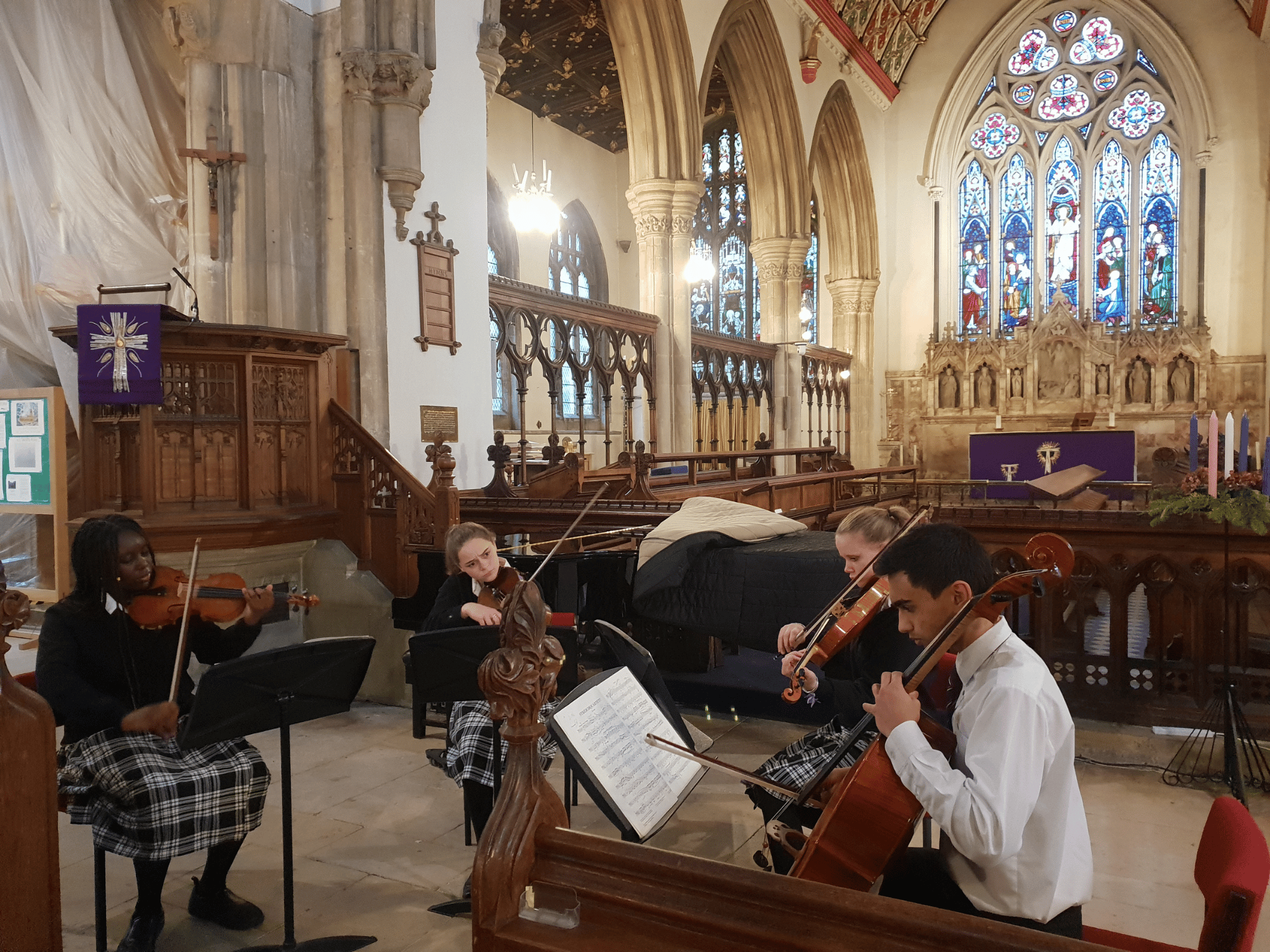 A student string quartet play in a church