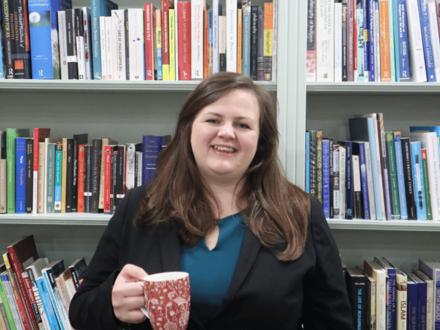 Teacher standing in front of books