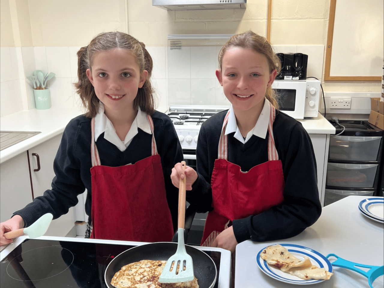 Two girls cooking pancakes