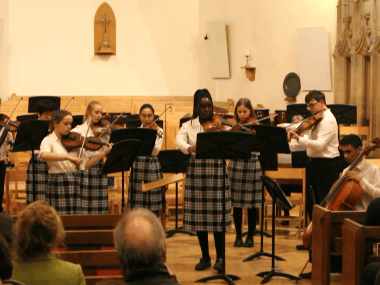 Student soloists (two violins and one cello) perform with orchestra in concert