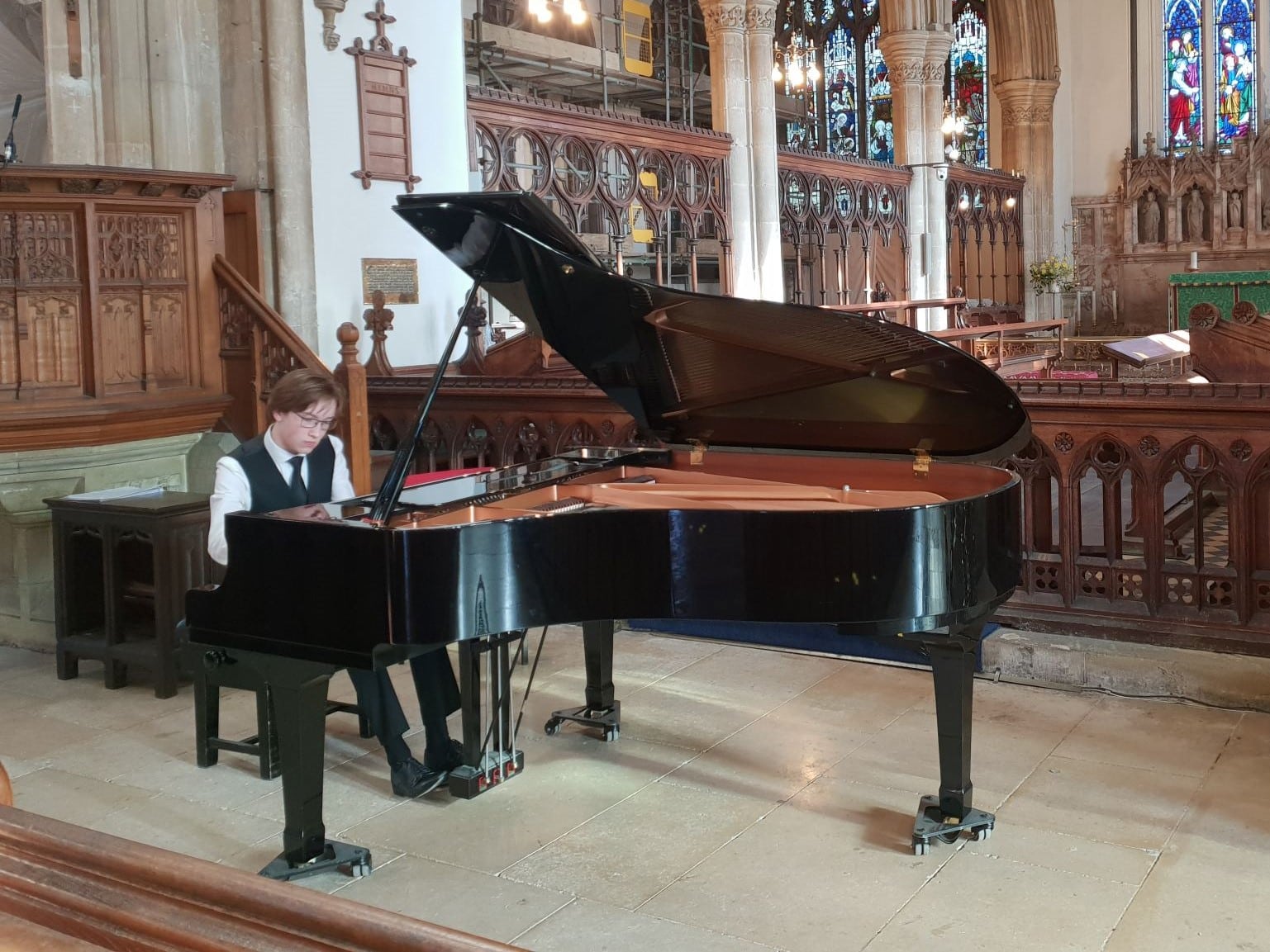 Student gives piano recital in a church