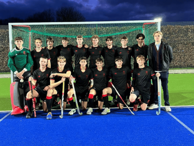 Hockey players posing in front of goal