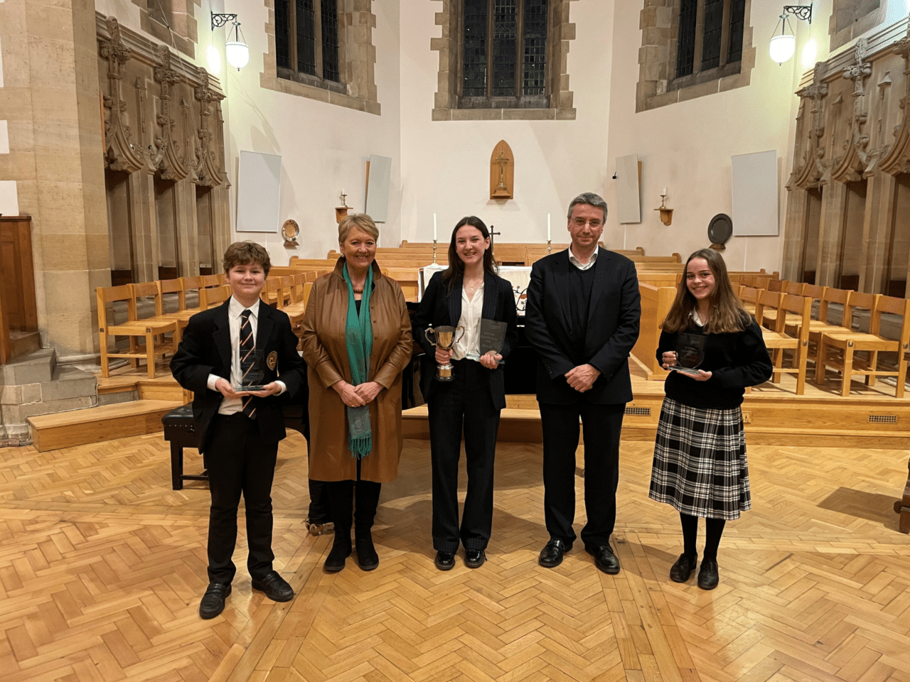 The three winners of the Singing Competition holding their trophies, with the adjudicators