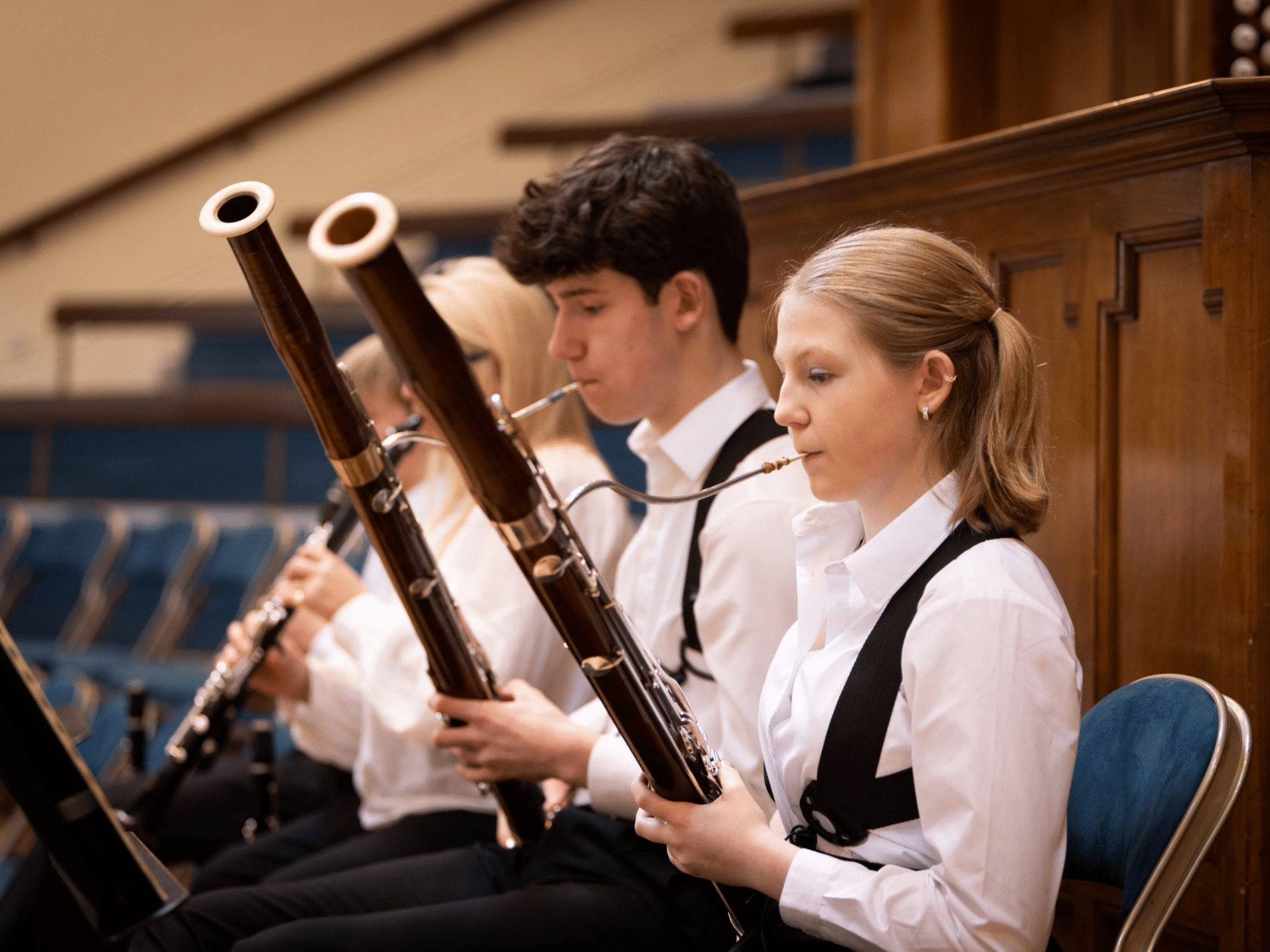 Closeup of students playing bassoons and clarinets in school orchestra