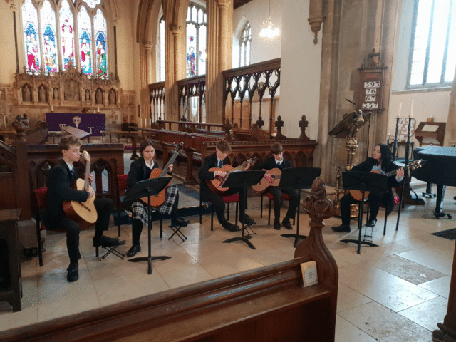 A group of students play in a classical guitar group