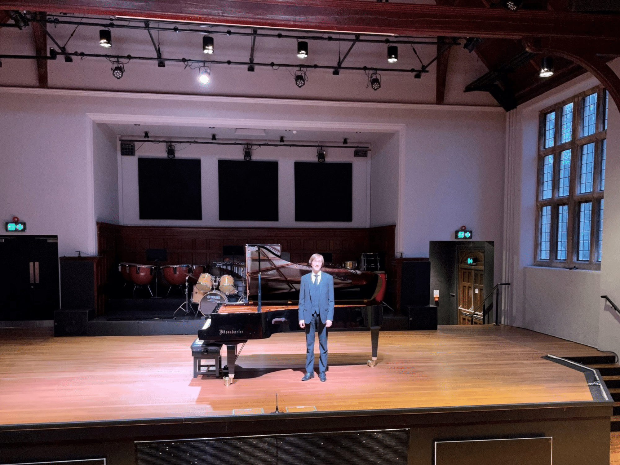 Student stands in front of piano after recital