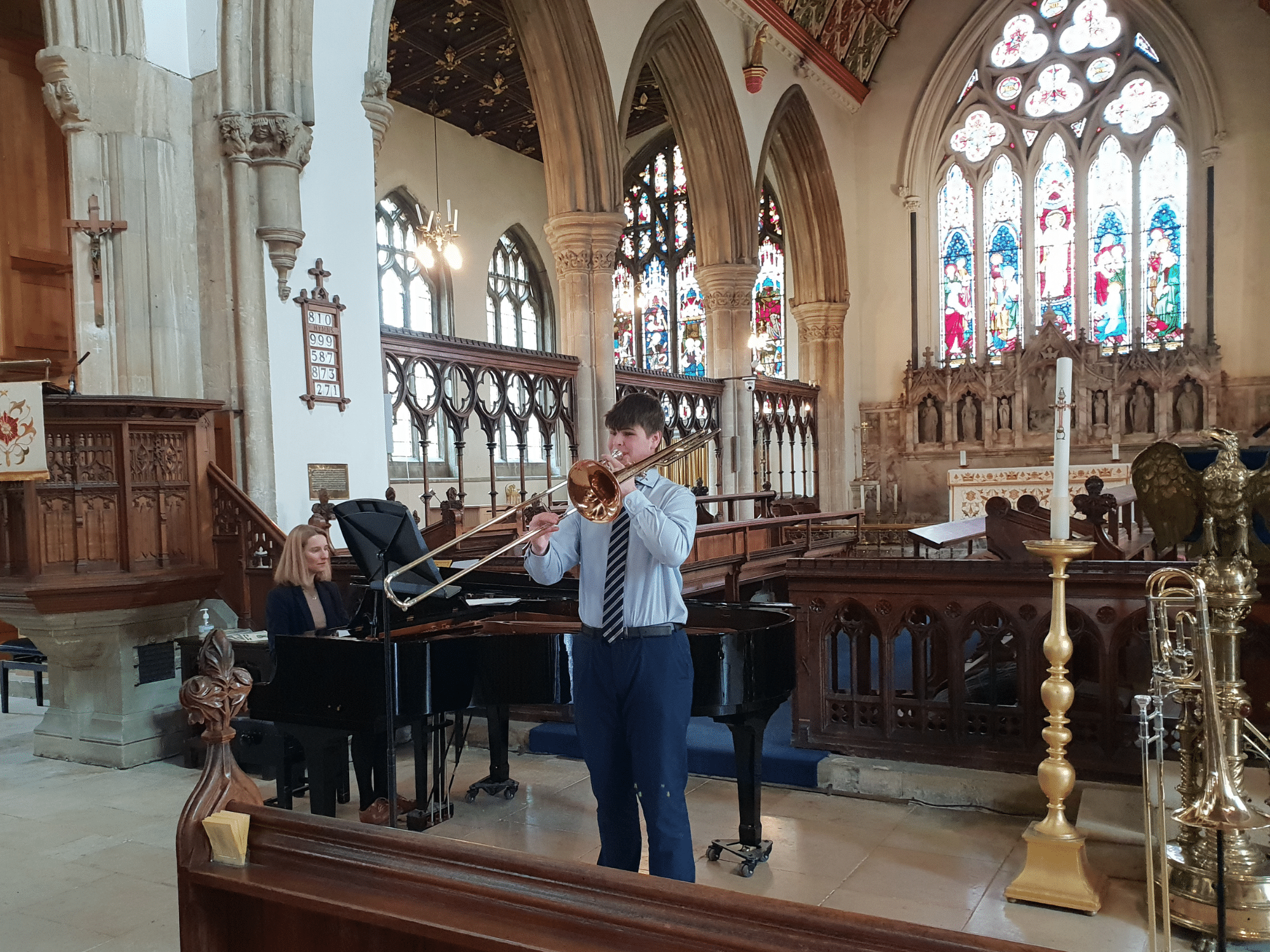 Student plays trombone in recital in church