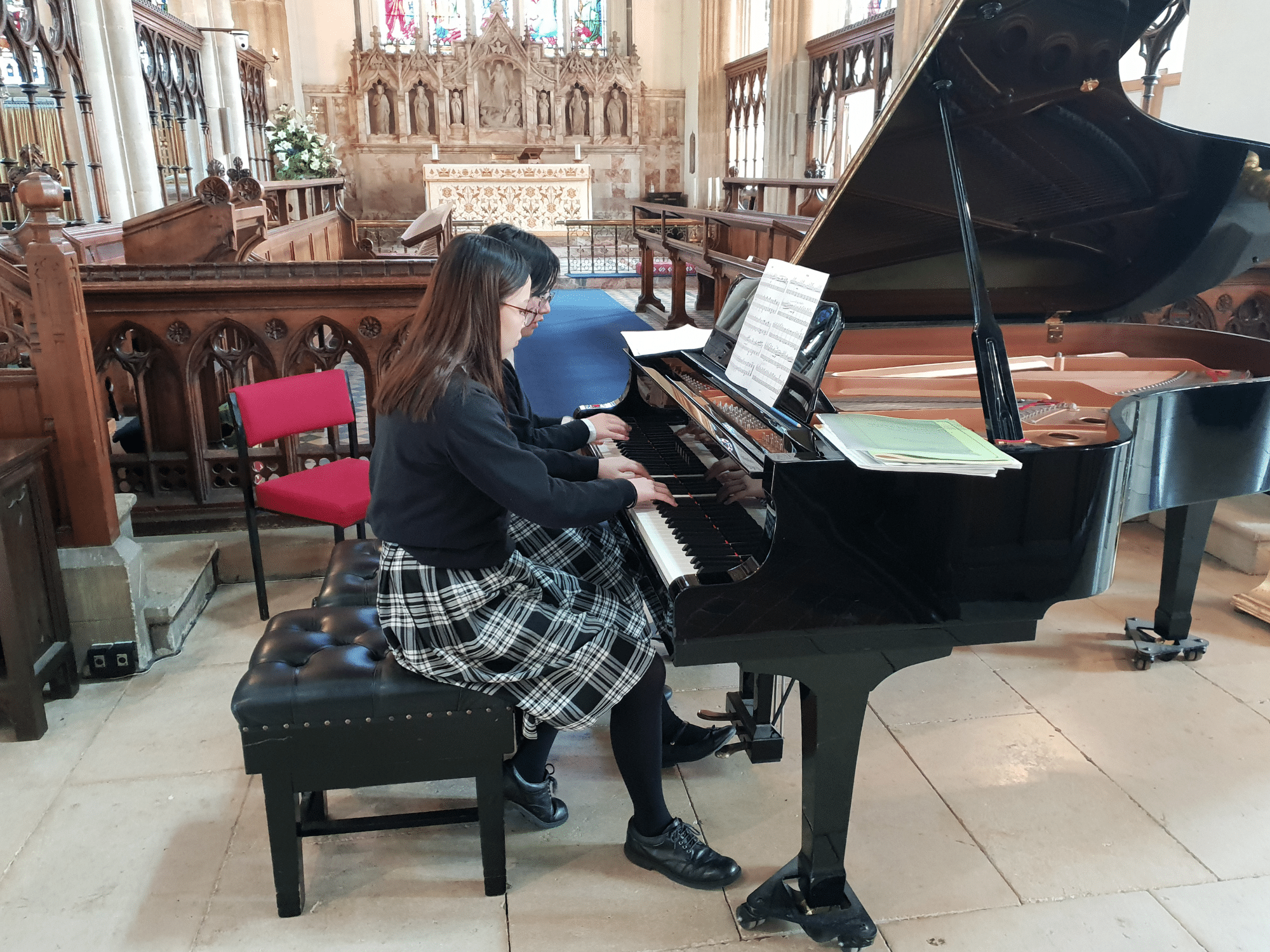 Two pupils perform a piano duet