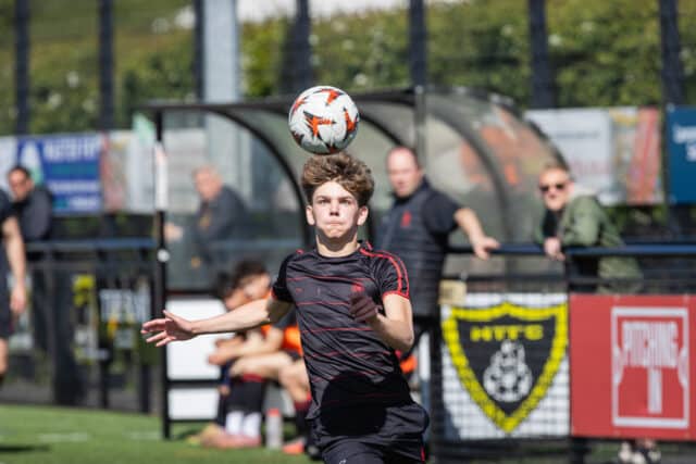 A boy in football kit heading a ball