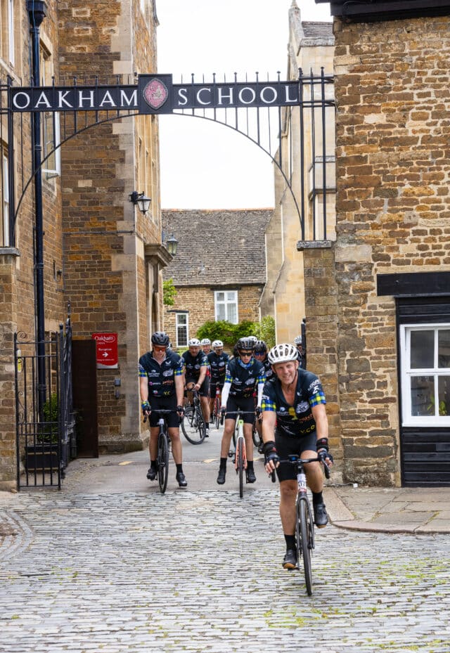 A group of cyclists including former rugby player Lewis Moody in front of the Oakham School gates