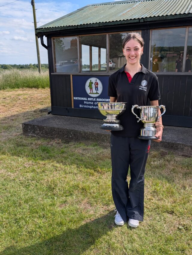 A girl wearing a tracksuit and holding two cups